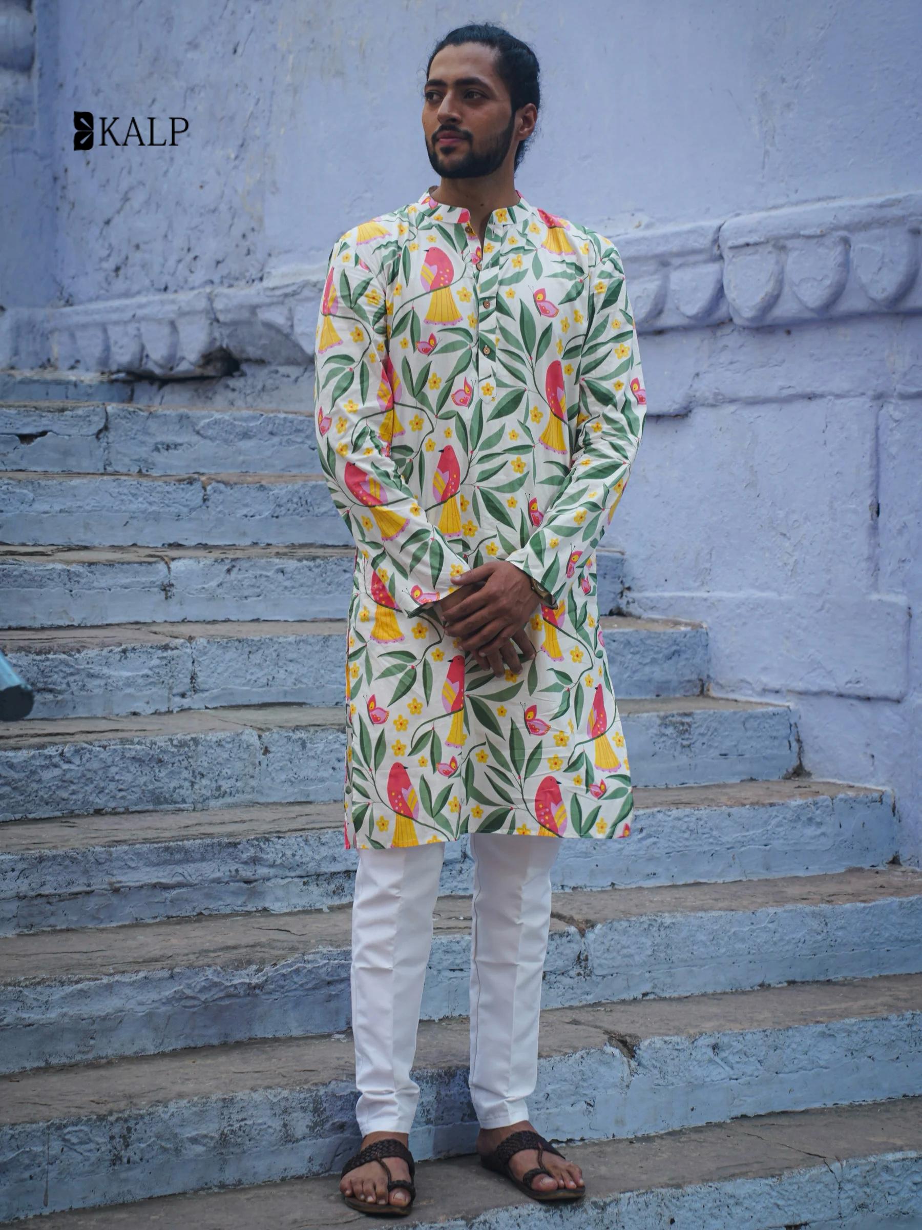 Man wearing floral print kurta for men with white pants and sandals standing on blue stone steps